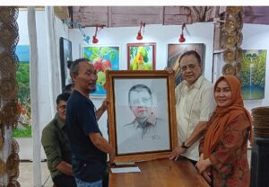 Syahrial memberikan cinderamata berupa lukisan yang menggambarkan wajah Varial Adhi Putra