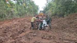 Sigap Bantu Warga, Satgas TMMD Ke 123 Kodim 0416/Bute Bantu Dorong Motor di jalan Berlumpur